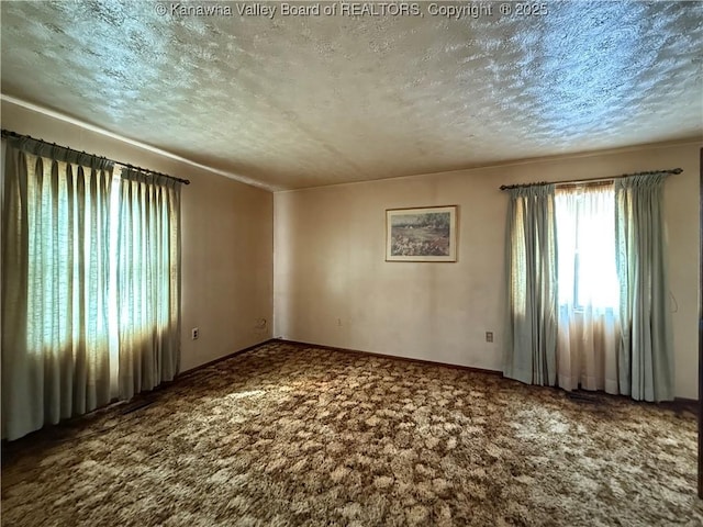 carpeted spare room with a textured ceiling