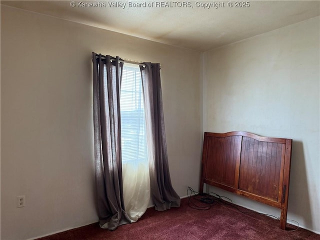 unfurnished bedroom with dark colored carpet