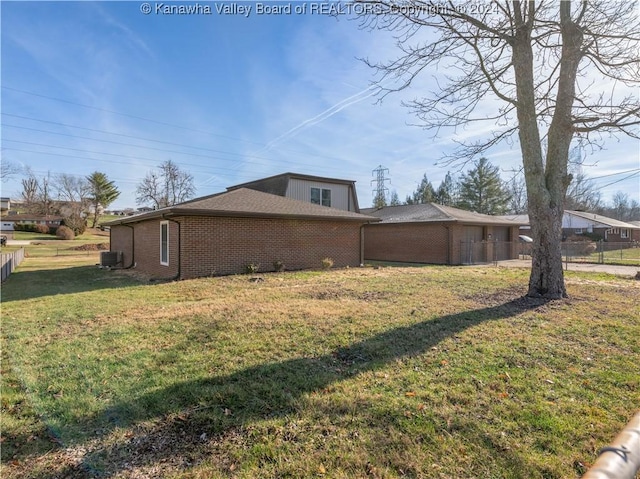 view of side of home with central AC unit and a lawn