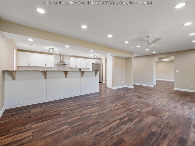 unfurnished living room featuring ceiling fan and dark hardwood / wood-style flooring