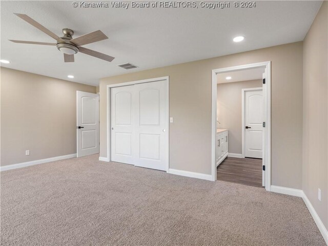 unfurnished bedroom with ceiling fan, ensuite bath, a closet, and carpet floors