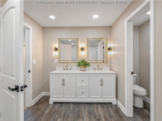 bathroom with toilet, hardwood / wood-style floors, and vanity