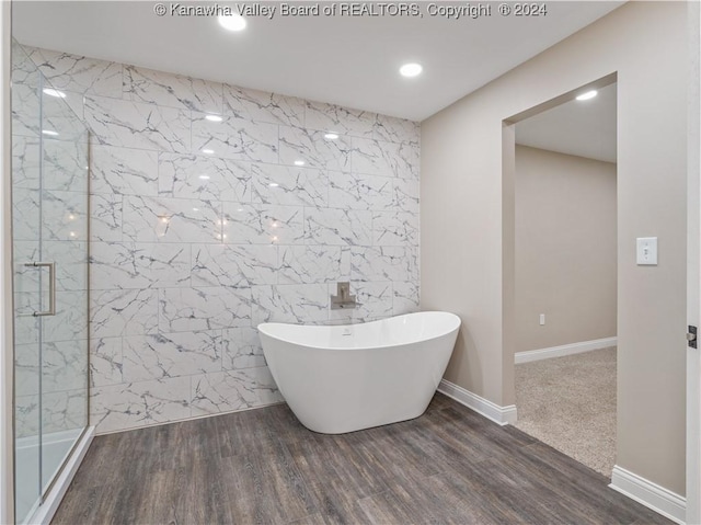 bathroom with separate shower and tub, tile walls, and hardwood / wood-style floors