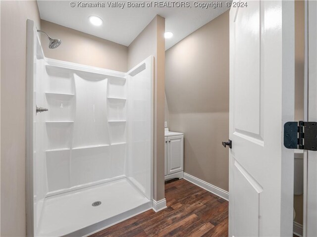 bathroom with hardwood / wood-style flooring and walk in shower