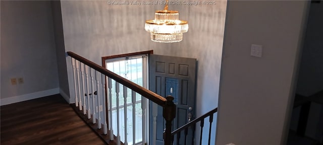 staircase with a notable chandelier and hardwood / wood-style floors