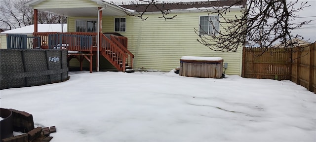 snow covered rear of property featuring a deck