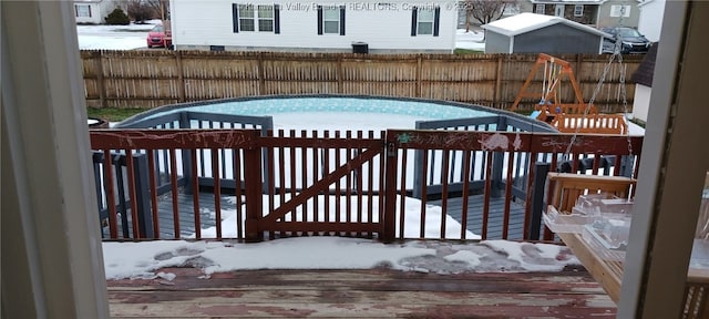 snow covered pool featuring a wooden deck