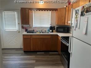 kitchen with dark wood-type flooring, white refrigerator, electric range, and sink