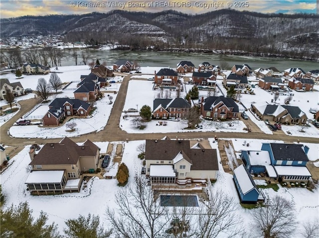 snowy aerial view featuring a mountain view