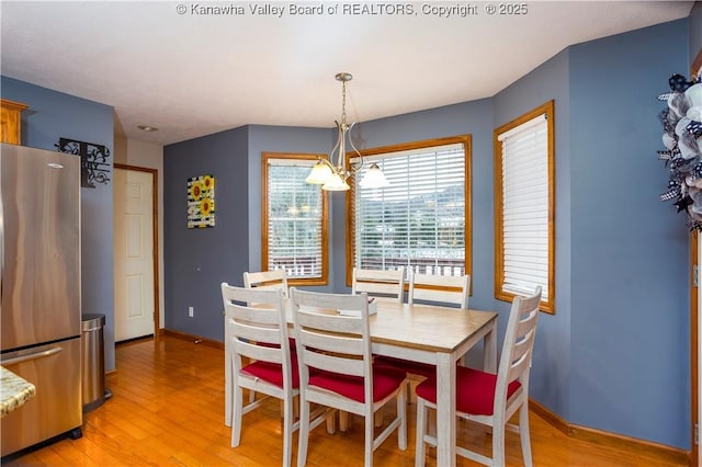 dining area with a chandelier and light wood-type flooring