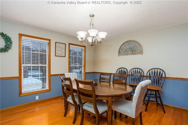 dining space with a chandelier and light wood-type flooring