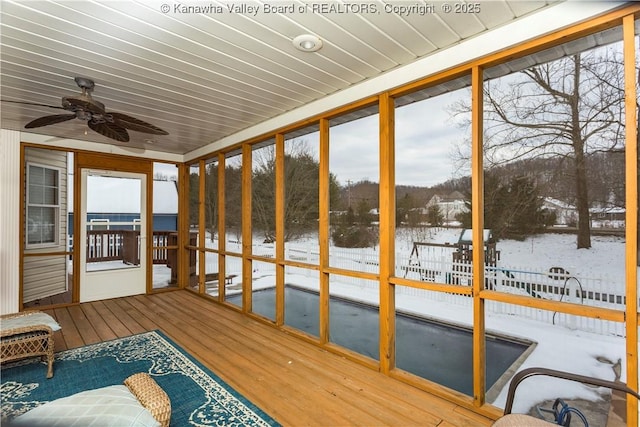 unfurnished sunroom featuring ceiling fan