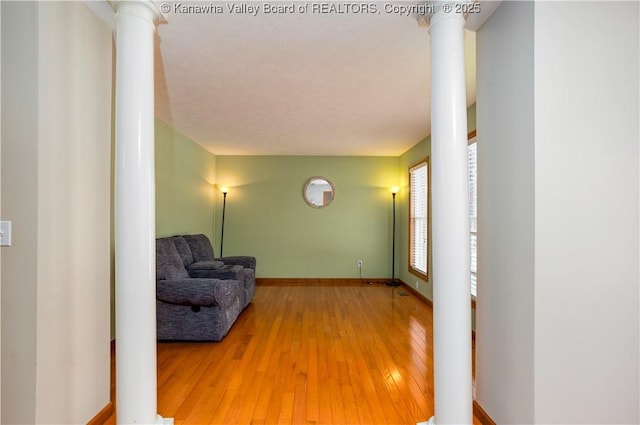 interior space featuring decorative columns and wood-type flooring