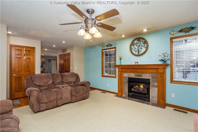 carpeted living room featuring ceiling fan and a fireplace