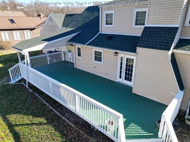 rear view of property with french doors, roof with shingles, and a wooden deck