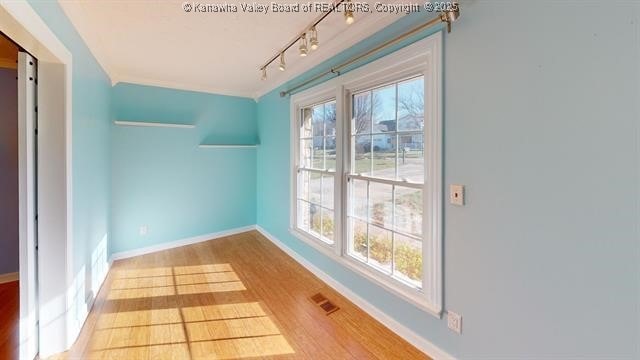 bonus room featuring a healthy amount of sunlight, visible vents, baseboards, and wood finished floors