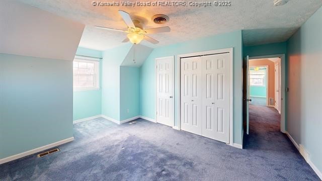 additional living space with a textured ceiling, lofted ceiling, a ceiling fan, visible vents, and baseboards