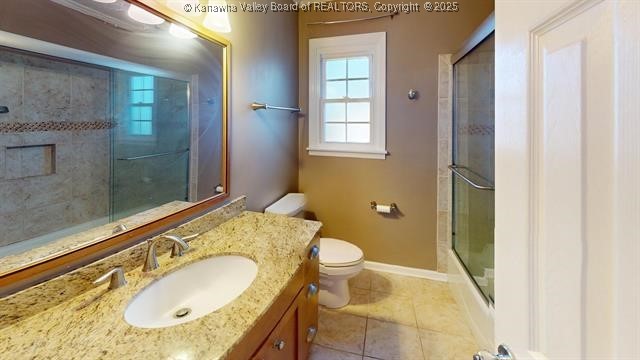 full bathroom with toilet, an enclosed shower, vanity, tile patterned flooring, and baseboards