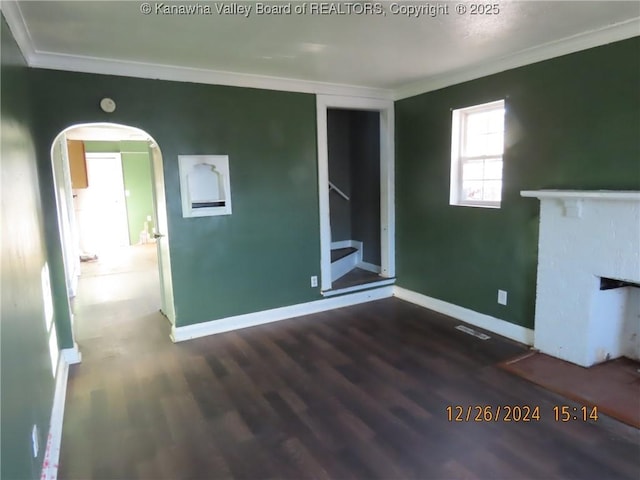 unfurnished living room featuring ornamental molding, a fireplace, and dark hardwood / wood-style floors