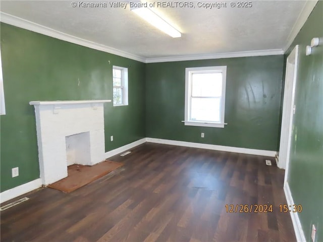 unfurnished living room with dark wood-type flooring, a brick fireplace, a healthy amount of sunlight, and crown molding