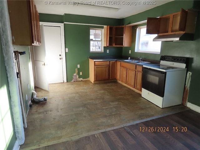 kitchen with a wealth of natural light, dark hardwood / wood-style floors, electric range, and sink