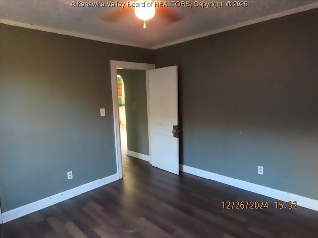 empty room with ceiling fan, dark hardwood / wood-style floors, and crown molding