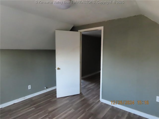 bonus room with dark wood-type flooring and vaulted ceiling