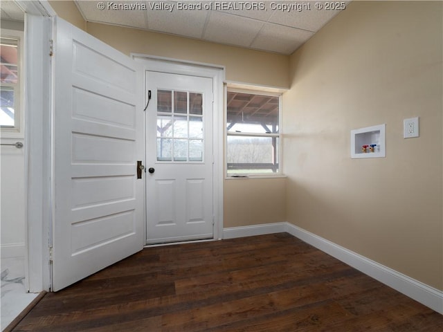 doorway with dark hardwood / wood-style flooring and a drop ceiling