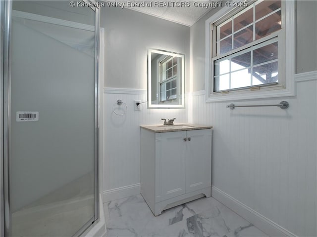 bathroom featuring a textured ceiling, walk in shower, and vanity