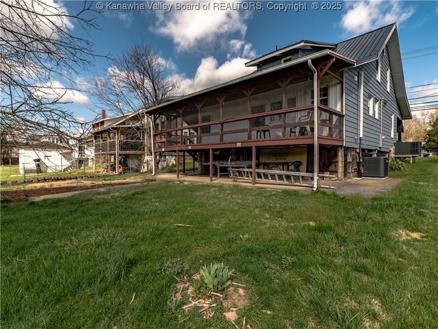 rear view of house with central AC unit, a lawn, and a patio