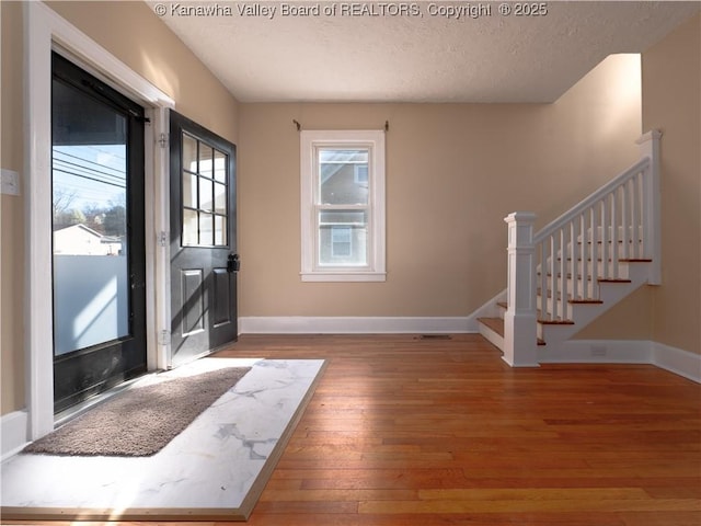 foyer with a textured ceiling and hardwood / wood-style floors