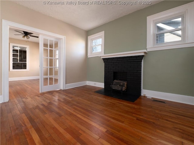 unfurnished living room with a textured ceiling, ceiling fan, and hardwood / wood-style flooring