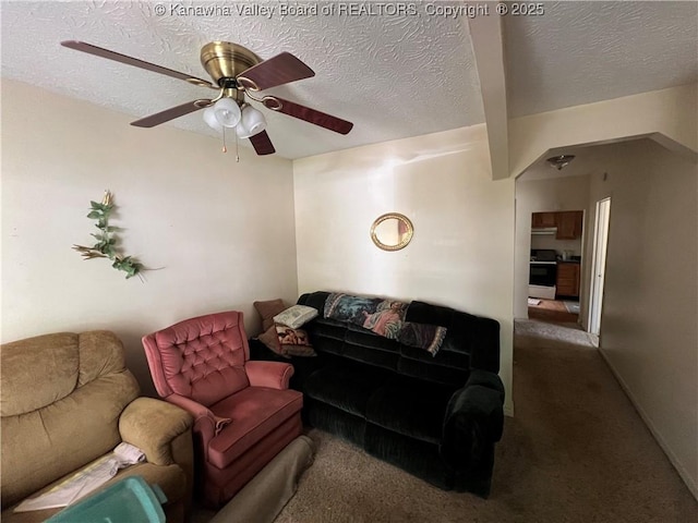 living room with a textured ceiling, ceiling fan, and carpet floors