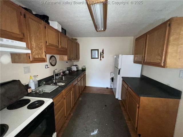 kitchen with a textured ceiling, white fridge, electric range, and sink