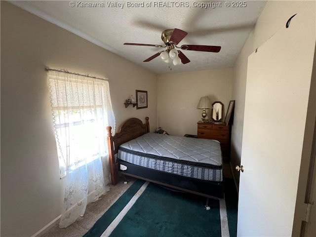 carpeted bedroom featuring a textured ceiling and ceiling fan