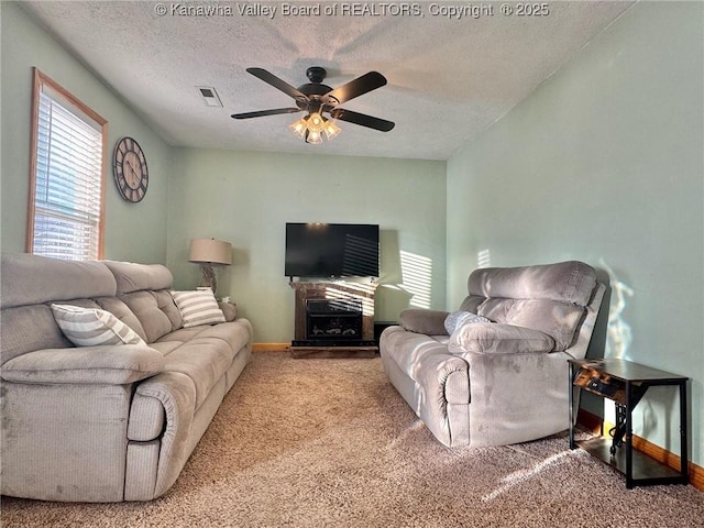 carpeted living room with a textured ceiling and ceiling fan