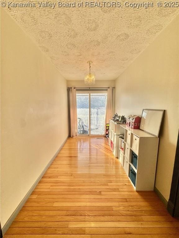 interior space featuring hardwood / wood-style floors, a textured ceiling, and a chandelier