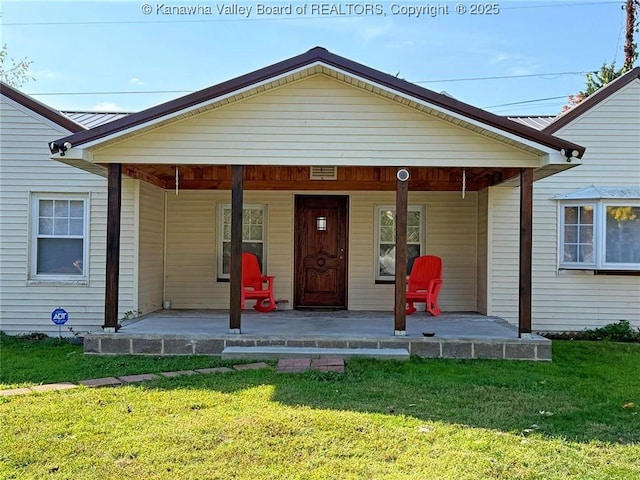 rear view of property with a porch and a lawn