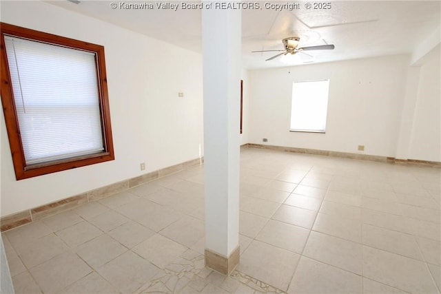 spare room with ceiling fan and light tile patterned floors