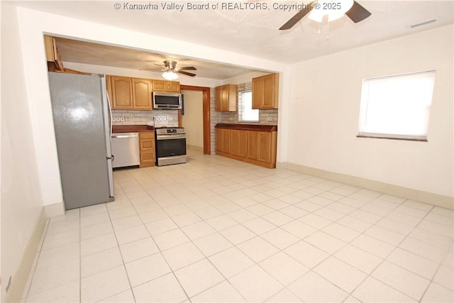 kitchen with tasteful backsplash, ceiling fan, stainless steel appliances, and light tile patterned floors