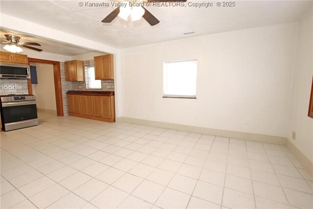 kitchen with backsplash, light tile patterned floors, ceiling fan, and appliances with stainless steel finishes