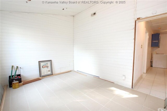 tiled empty room with vaulted ceiling