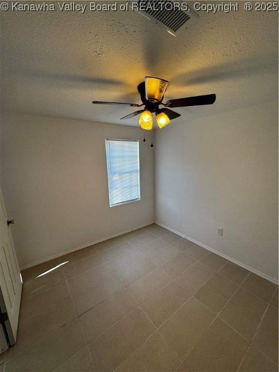 empty room featuring ceiling fan and a textured ceiling