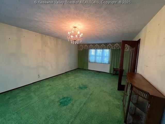 unfurnished room with a chandelier, a textured ceiling, and carpet flooring