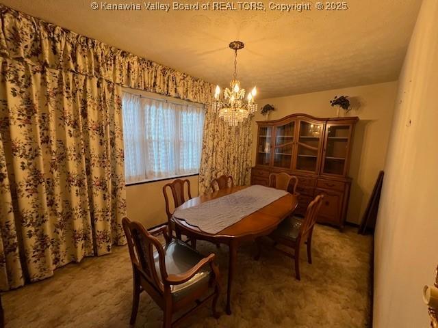 dining room with carpet and a notable chandelier