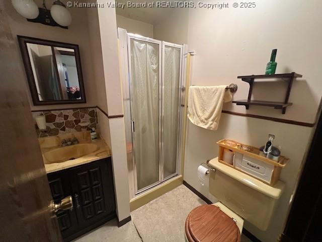 bathroom with vanity, tile patterned flooring, a shower with door, and toilet