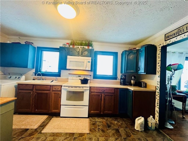 kitchen featuring white appliances, a textured ceiling, sink, ornamental molding, and washer and dryer