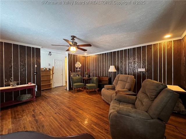 living room with ceiling fan, crown molding, a textured ceiling, and wood-type flooring