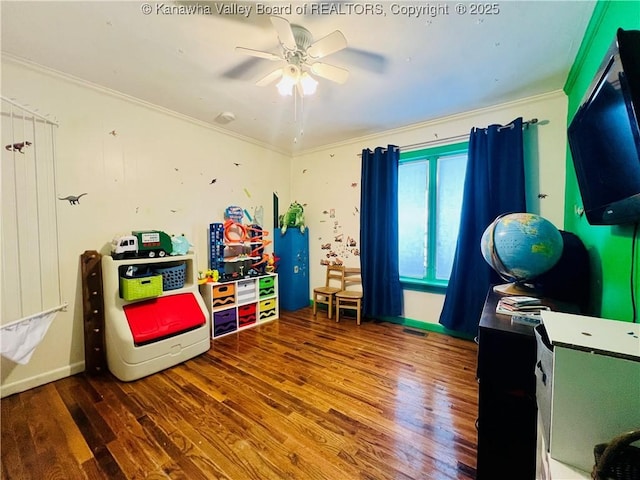 rec room with wood-type flooring, ceiling fan, and ornamental molding