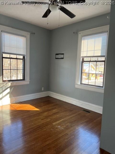 spare room with ceiling fan and dark hardwood / wood-style flooring